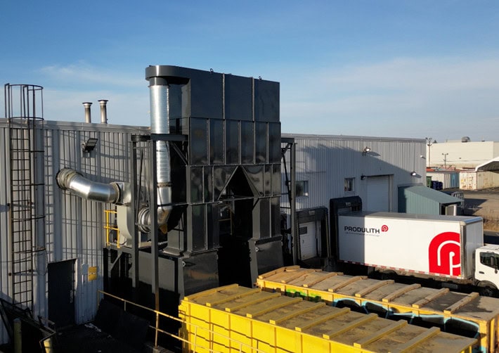 Image de l'installation industrielle chez Produlith, montrant des équipements de ventilation et un camion de livraison avec le logo de Produlith.