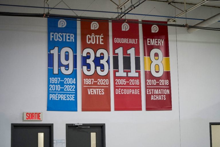 Image de bannières honorifiques affichées chez Produlith, mettant en avant les noms et années de service des employés Foster, Côté, Goudreault et Emery