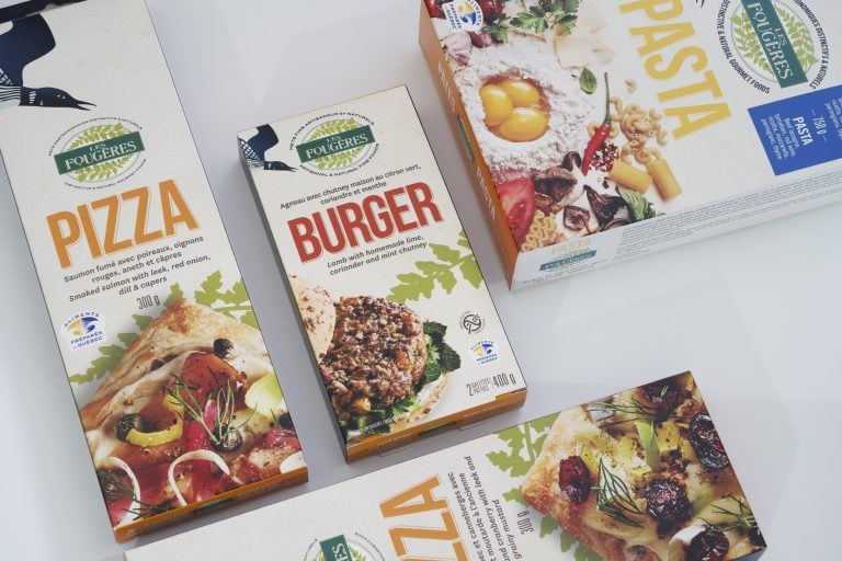 Emballages de produits alimentaires de la marque Les Fougères, incluant des pizzas, des burgers et des pâtes, disposés sur une surface blanche.